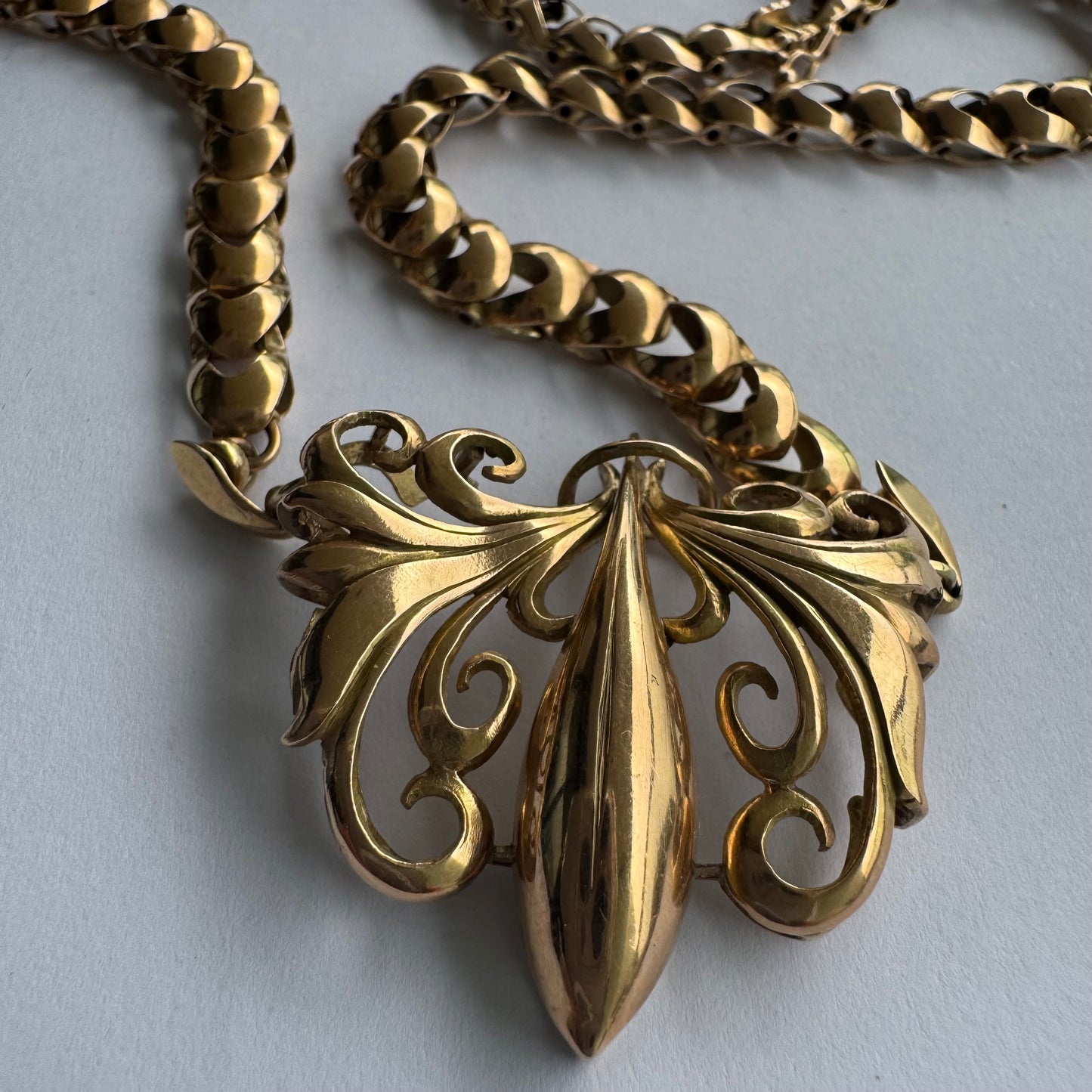 שרשרת זהב 14 קראט בעלת עיטור פלר דה ליס (Fleur-de-lis) אמנותי, המעוצב בקווים מעוגלים של עלי שושן בסגנון אר נובו.