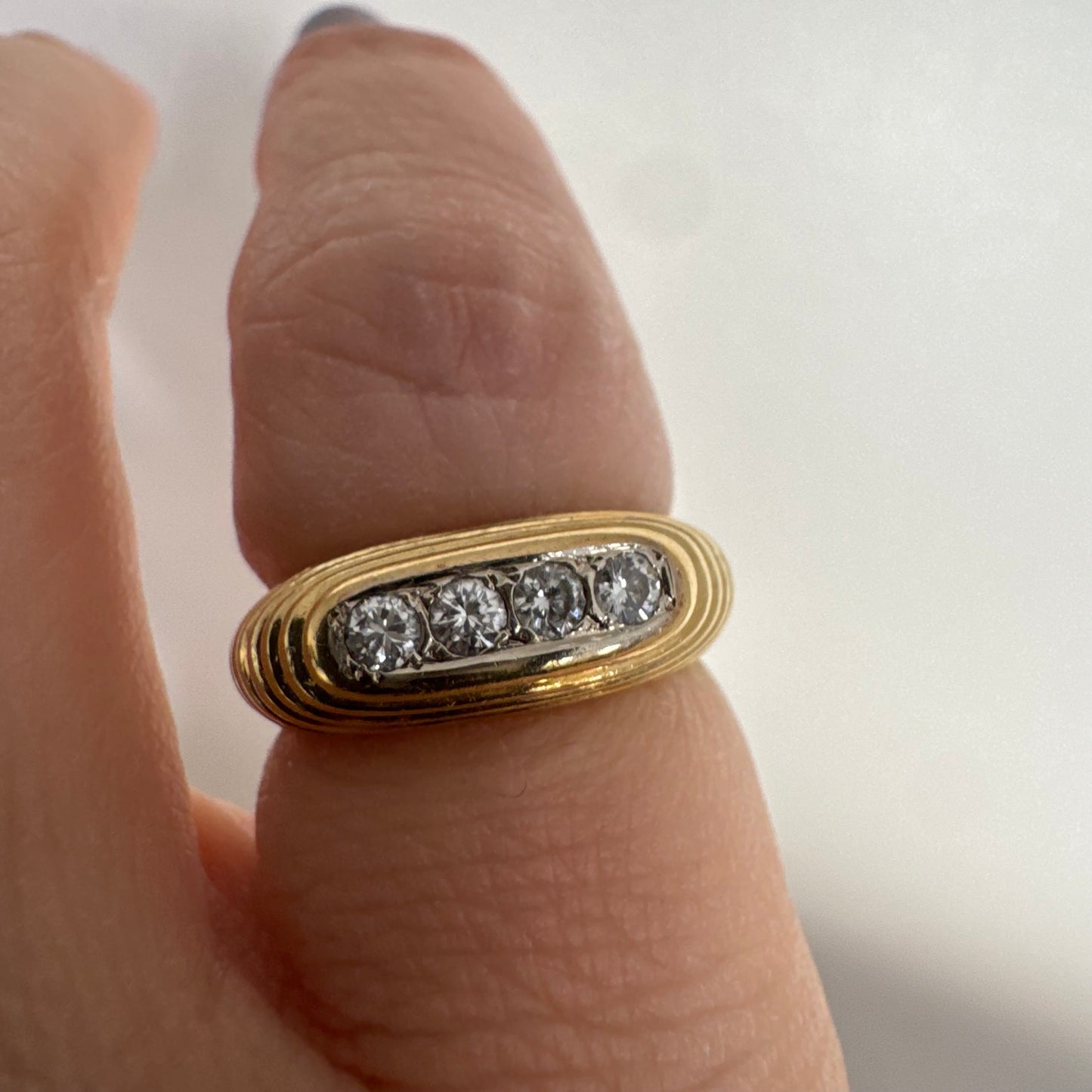 טבעת זהב צהוב 14 קראט בעיצוב אליפטי מוארך, משובצת חמישה יהלומים עגולים בשיבוץ תעלה.