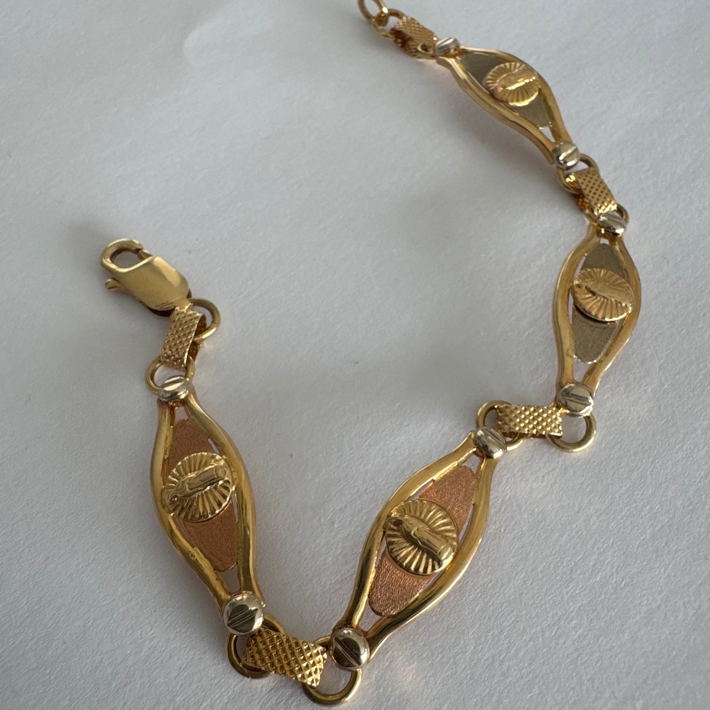 צמיד זהב צהוב 14 קראט עם אלמנט מרכזי בדמות מריה הקדושה, מוקפת קרני אור.