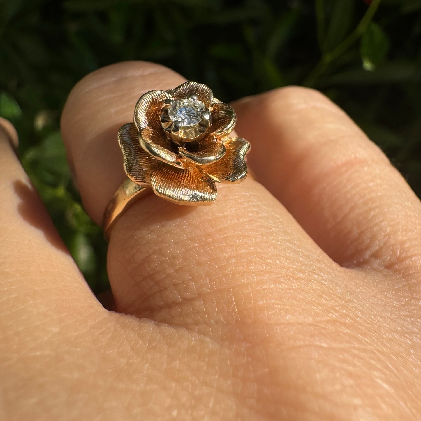 14K Gold floral ring set with delicately textured petals and a sparkling Diamond at the center