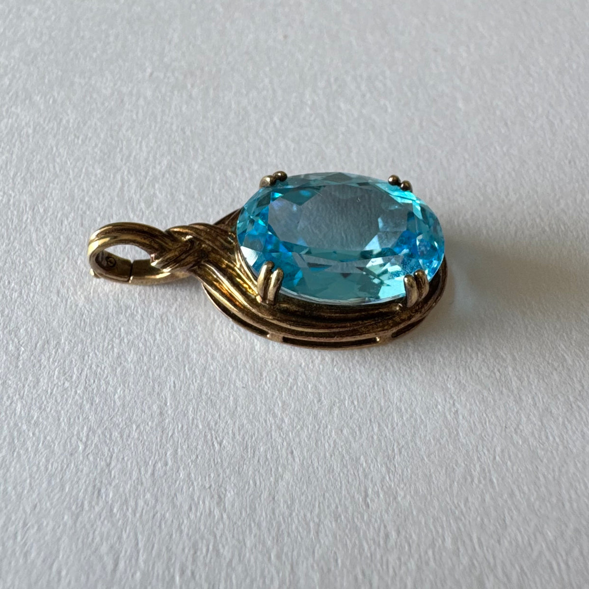תליון זהב 9 קראט משובץ אבן בלו טופז גדולה בחיתוך אובלי.