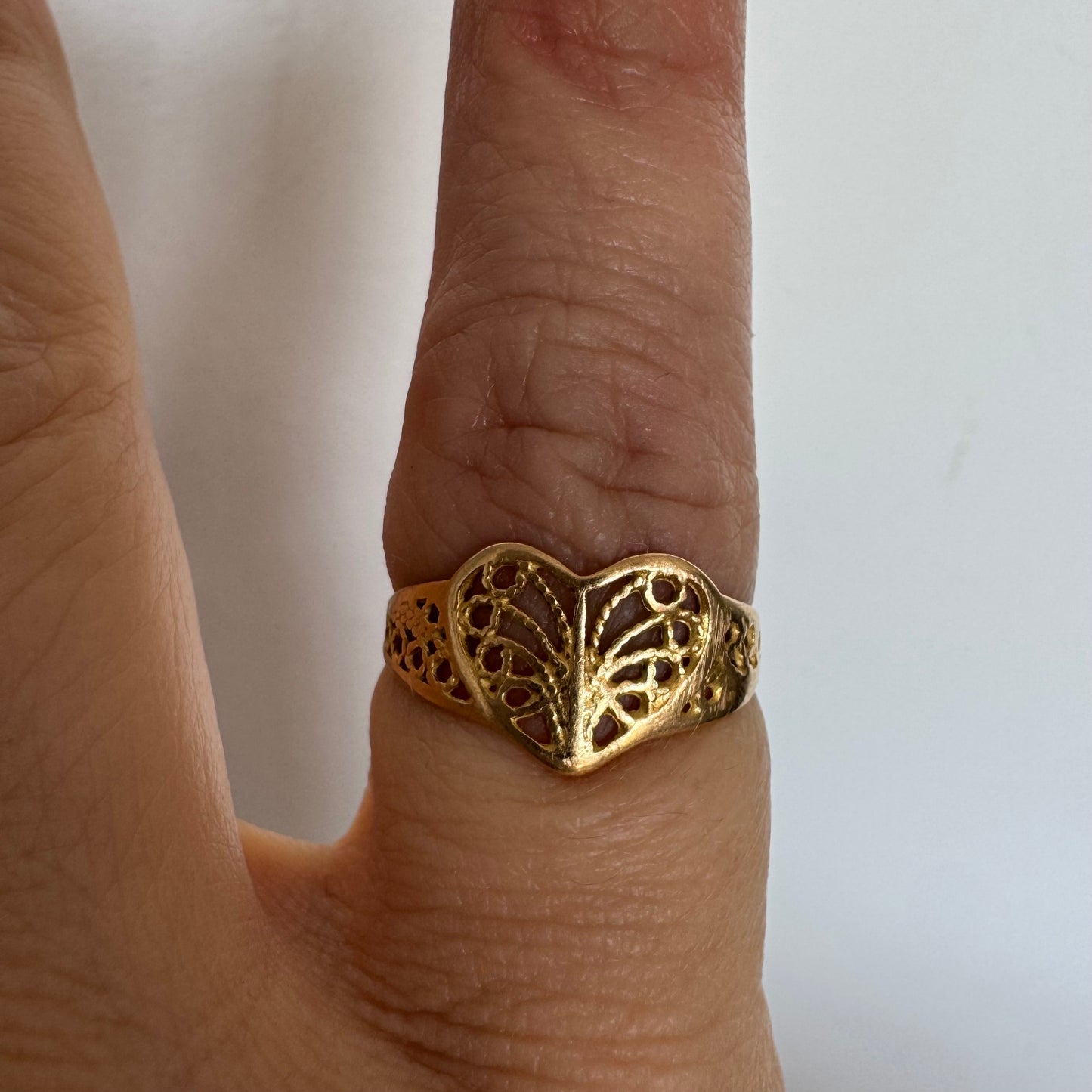 טבעת זהב 21 קראט בעיצוב לב עדין עם עבודת פיליגרן פתוחה.