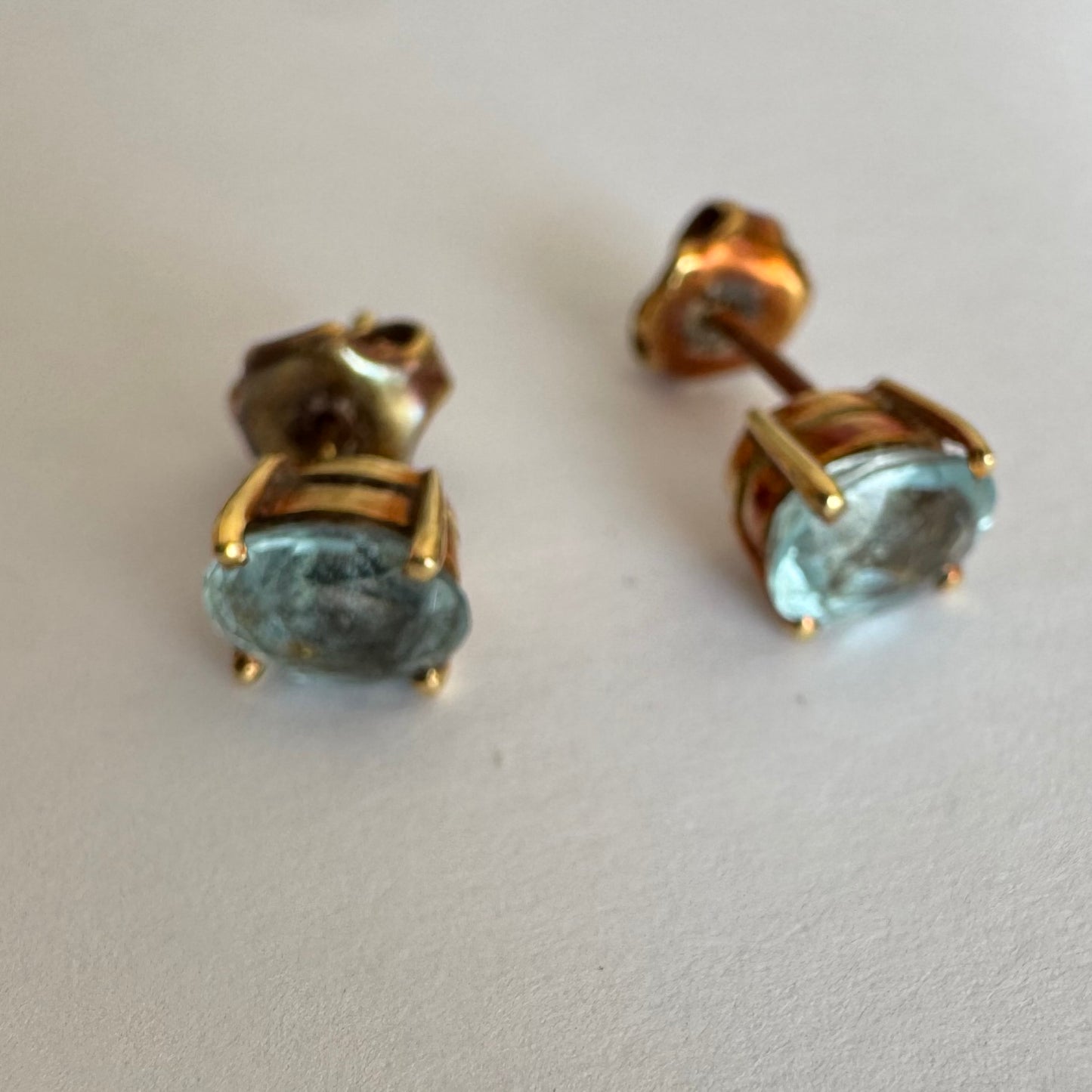 18K gold stud earrings set with oval-cut Aquamarines.