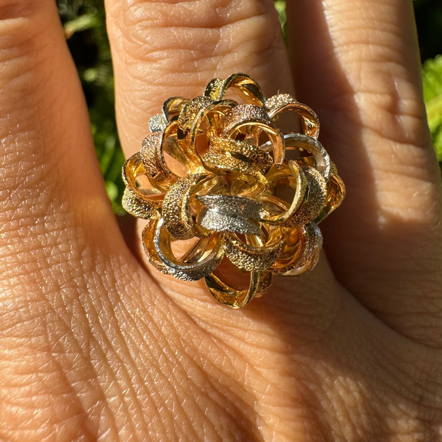 18K gold ring set with intricately textured loops in yellow, white, and rose gold, forming a bold floral-inspired sculptural design.