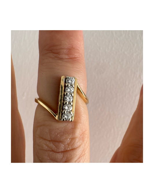 טבעת זהב 18 קראט בעיצוב מודרני ונקי, משובצת שורת יהלומים לבנים בחיתוך עגול במרכז.