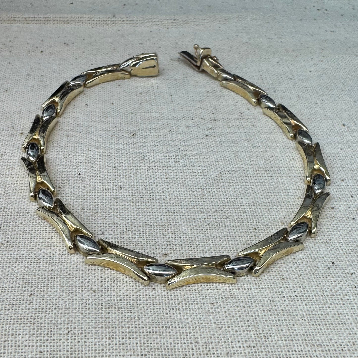 צמיד זהב צהוב וזהב לבן 14 קראט בעיצוב גאומטרי מיוחד, עם חיבורים בצורת X מזהב צהוב ושיבוצים מבריקים בזהב לבן