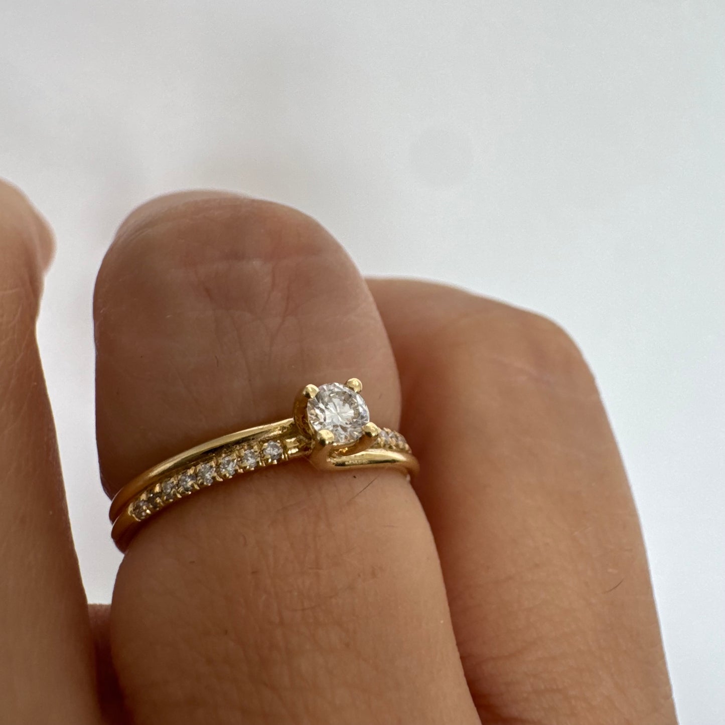 טבעת זהב צהוב 14 קראט משובצת יהלום מרכזי בחיתוך עגול ופס יהלומים עדין.