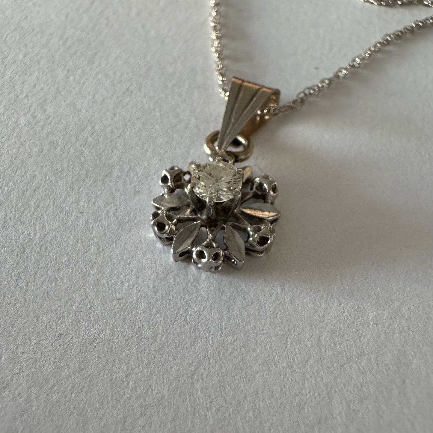 תליון זהב 14 קראט משובץ יהלום מרכזי בעיצוב פרח עדין ומלא נוכחות.