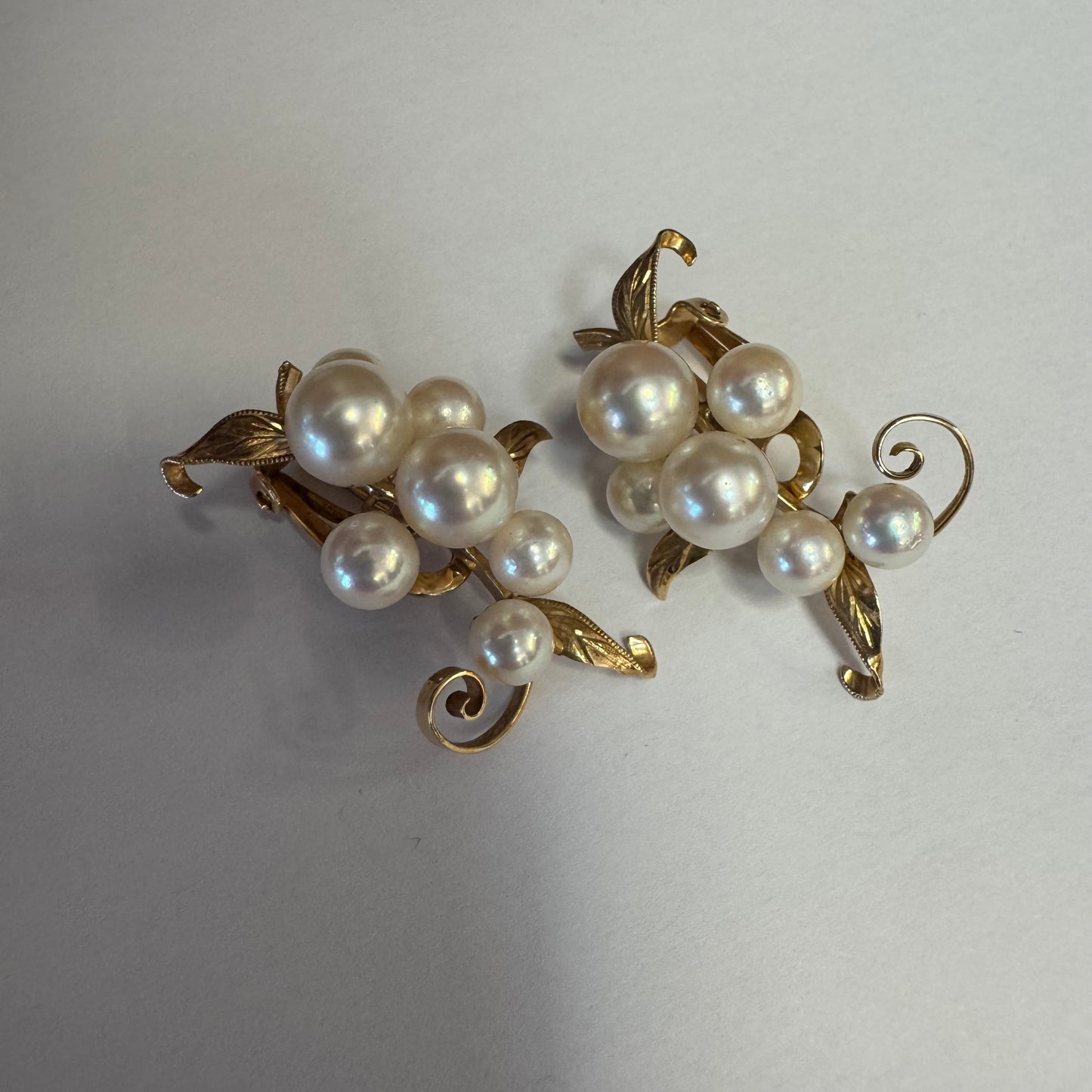 עגילי קליפס זהב 14 קראט, משובצים אשכול פנינים בגווני לבן-קרם.