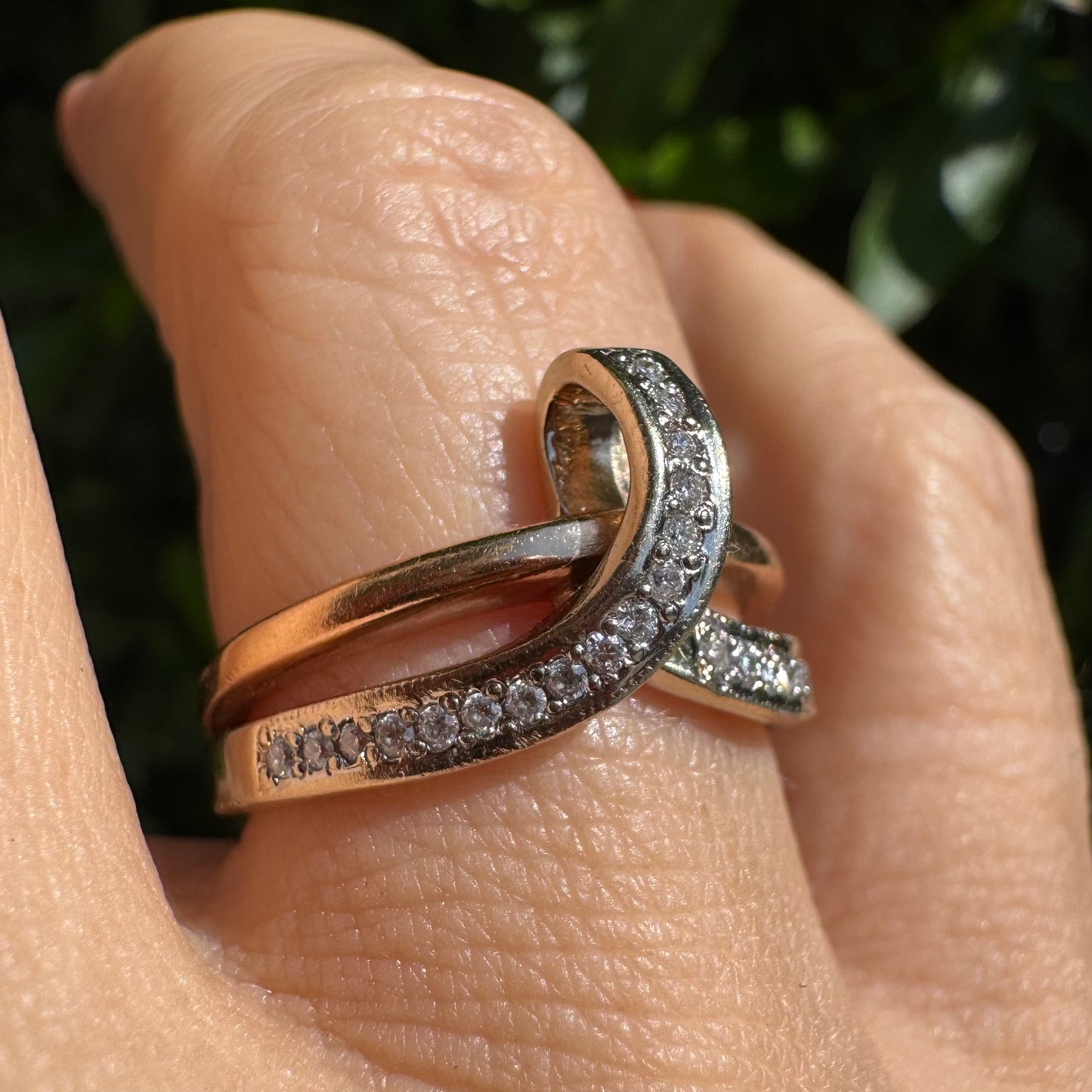 18K two-tone gold (rose & white) crossover ring featuring a row of sparkling Diamonds along each band, creating an elegant and modern design.