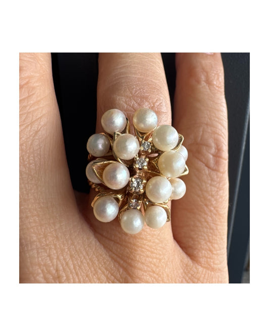 טבעת זהב צהוב 14 קראט משובצת בשפע של פנינים עגולות ולבנות, עם שורת יהלומים קטנים במרכז