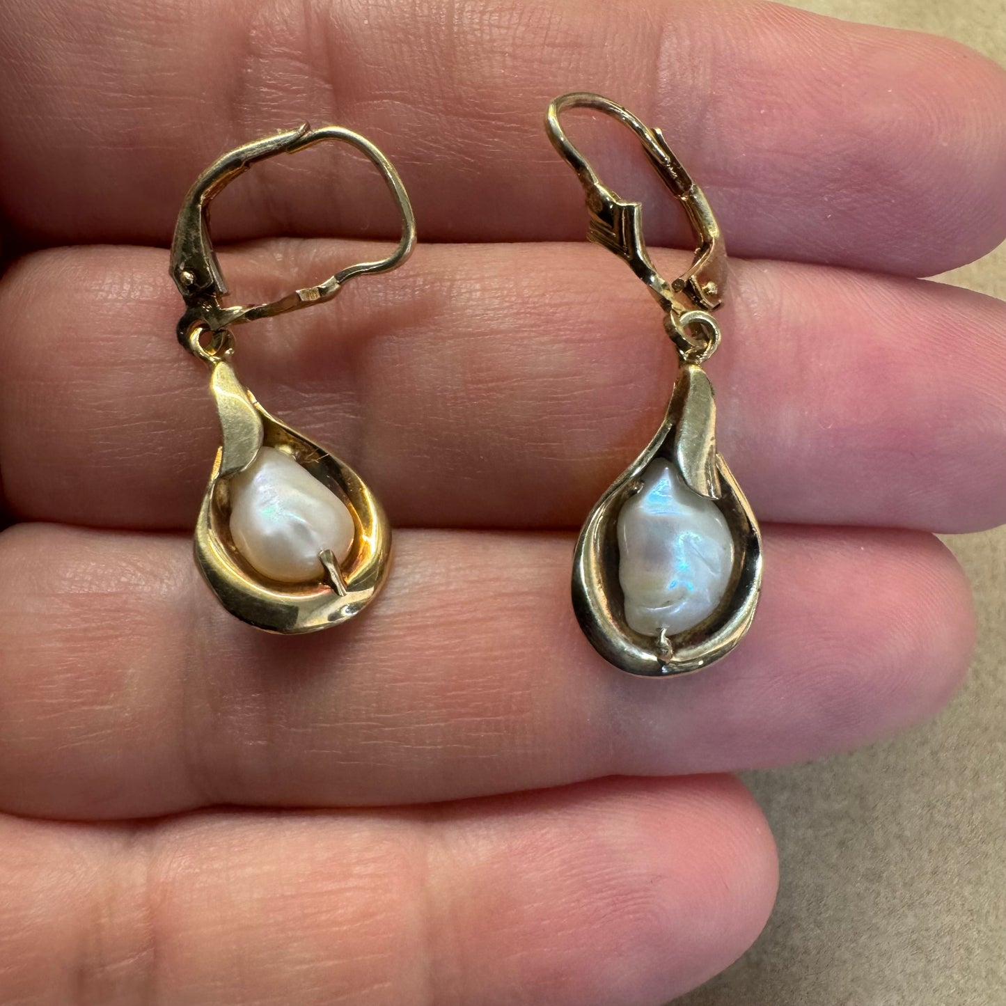 עגילי זהב צהוב 14 קראט משובצים פניני בארוק בעיצוב נוזלי ורך שמדגיש את היופי הטבעי של הפנינה