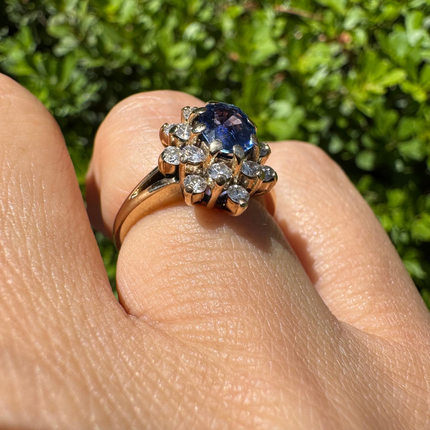 14K gold ring set with a vivid blue Sapphire surrounded by a sparkling halo of brilliant-cut Diamonds