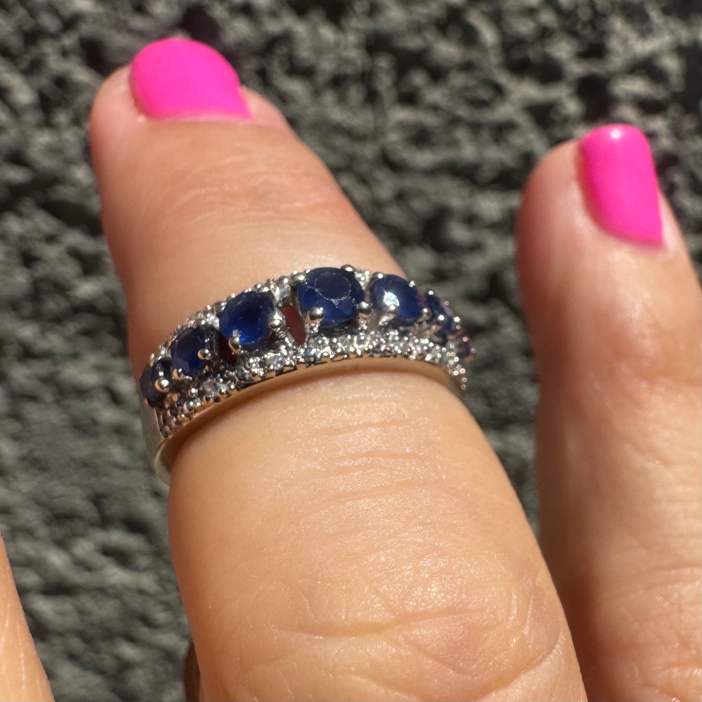 18K gold ring set with deep blue sapphires in a classic round cut, framed by two shimmering rows of brilliant Diamonds.
