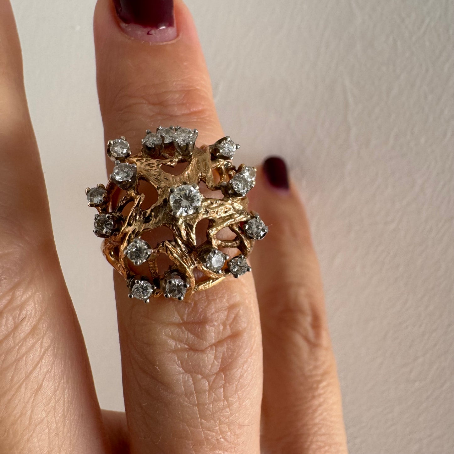 טבעת זהב 10 קראט בעיצוב פיסולי פתוח, משובצת יהלומים במבנה עגול דינמי.