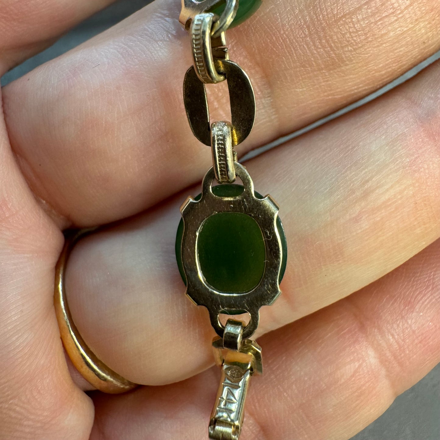 צמיד זהב צהוב 14 קראט משובץ באבני ג’ייד ירוקות בחיתוך קבושון (cabochon) בעיצוב אליפטי, המחוברות ביניהן בחוליות זהב עם טקסטורה מעניינת.