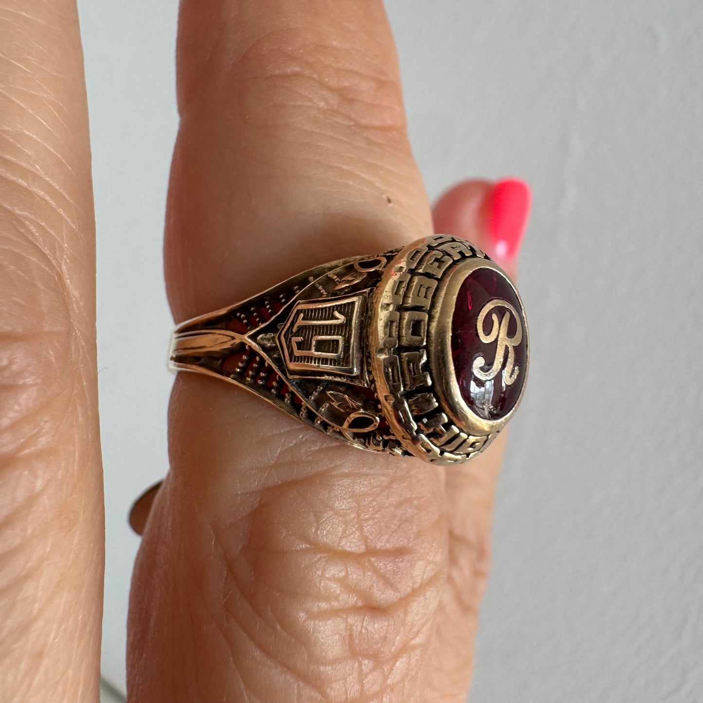 טבעת מחזור (Class Ring) מזהב 10 קראט, בעלת עיצוב אמריקאי קלאסי ובמרכזה אבן אדומה עם האות R עם חריטות וסמלים המעניקים לה אופי ייחודי ונוסטלגי.