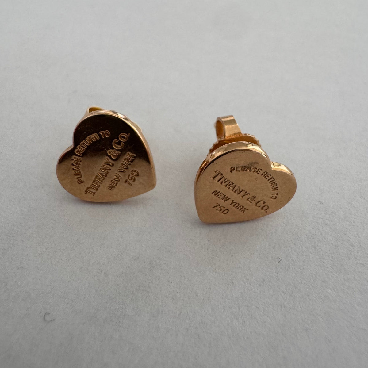 עגילים צמודים של Tiffany &amp; Co. עשויים זהב 18 קראט (750), בעיצוב לב אייקוני עם חריטת “Please Return to Tiffany & Co. New York”. 