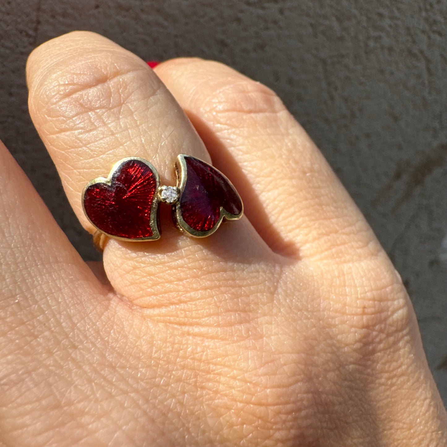 טבעת זהב צהוב 14 קראט “שני לבבות מחוברים״ מצופים אמייל אדום ויהלום משובץ במרכז