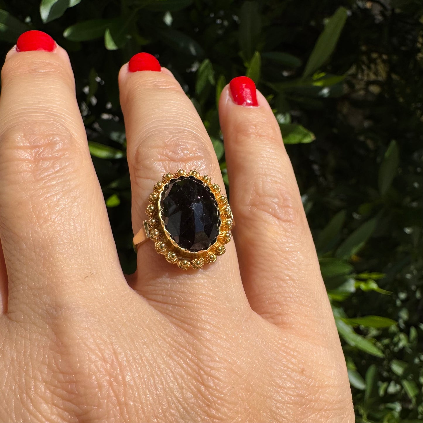 14K gold ring set with a large Garnet surrounded by delicate gold details