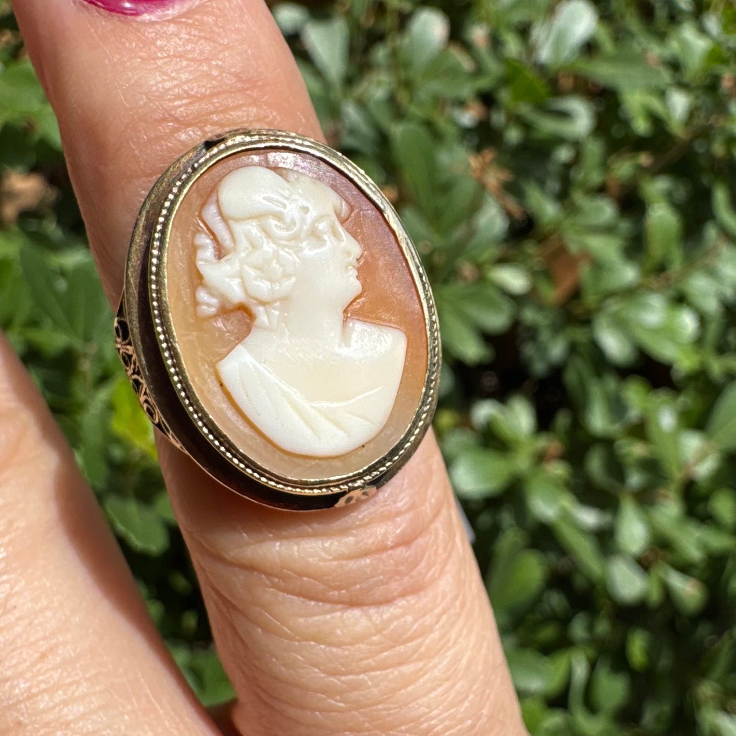 14K gold cameo ring featuring a finely carved portrait of a woman in profile, set in an oval bezel with intricate gold detailing