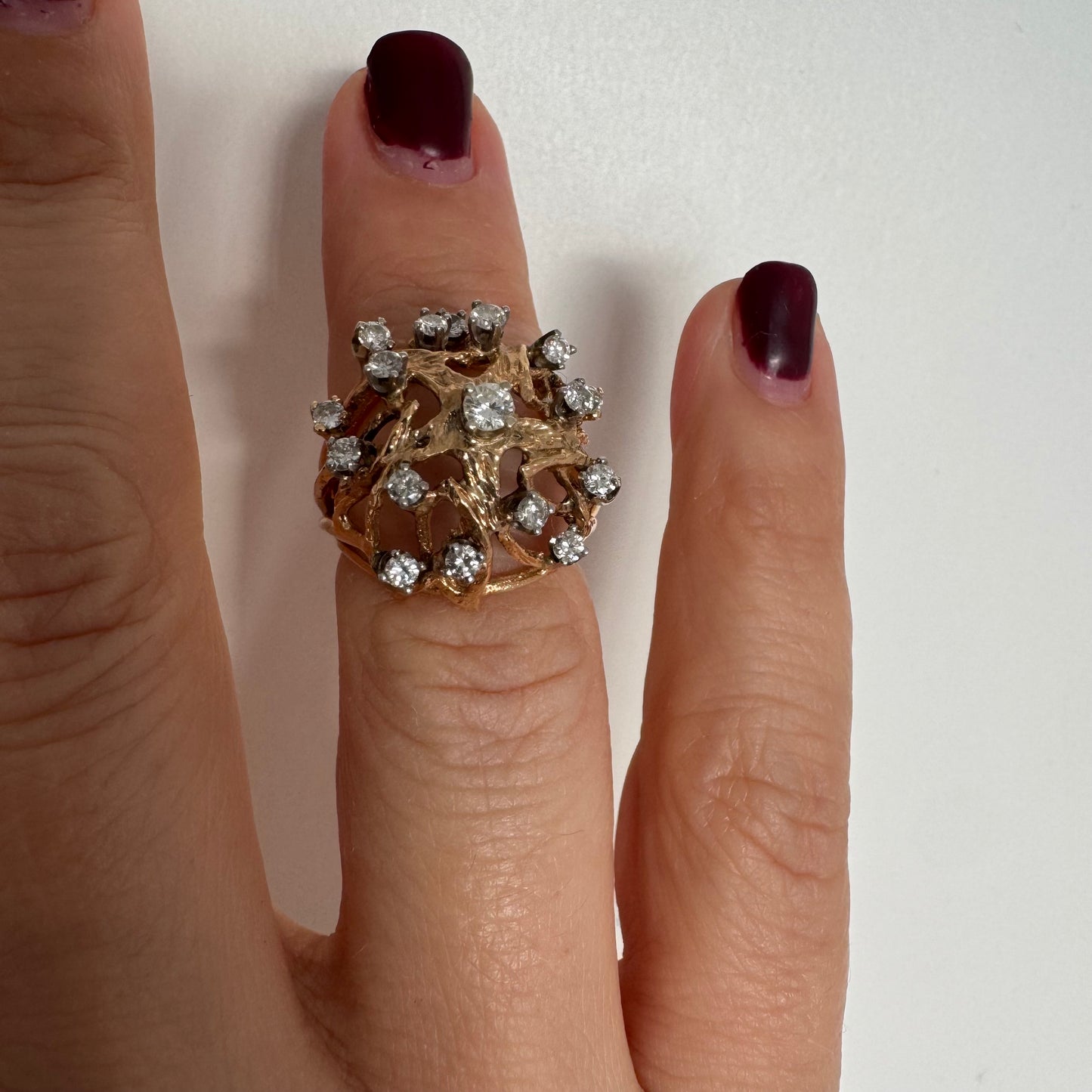 טבעת זהב 10 קראט בעיצוב פיסולי פתוח, משובצת יהלומים במבנה עגול דינמי.