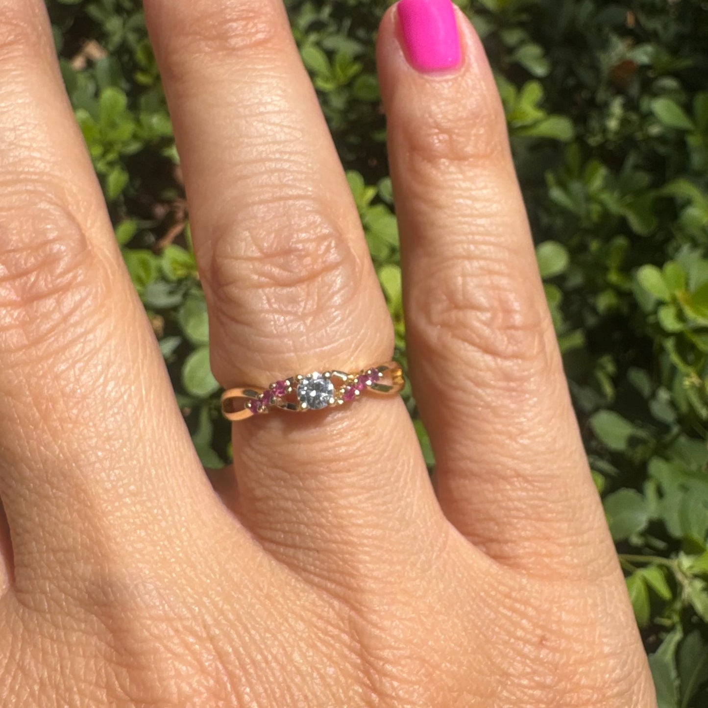 14K gold ring set with a central round Diamond, accented with Rubies along the band.