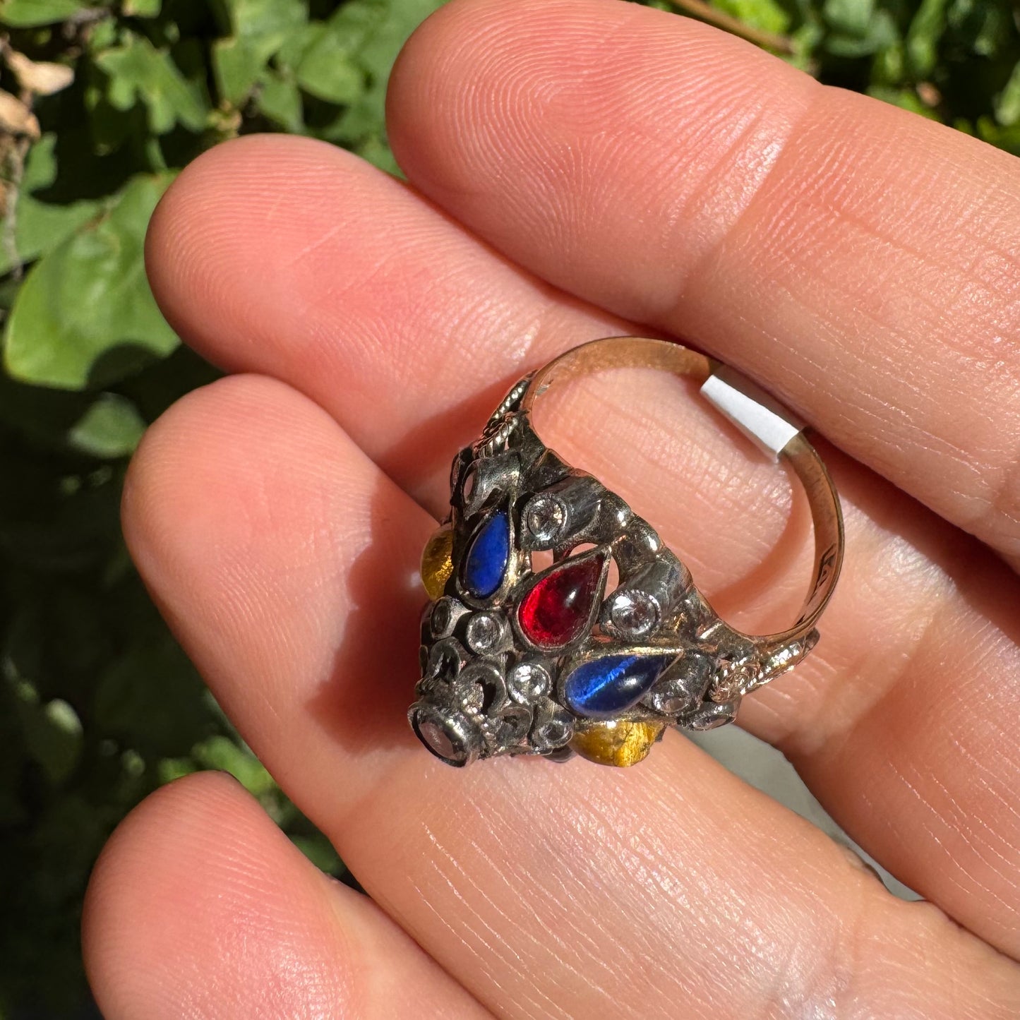 14K gold ring set with a central transparent gemstone surrounded by a vibrant mosaic of colorful gemstones -set in an ornate, handcrafted design