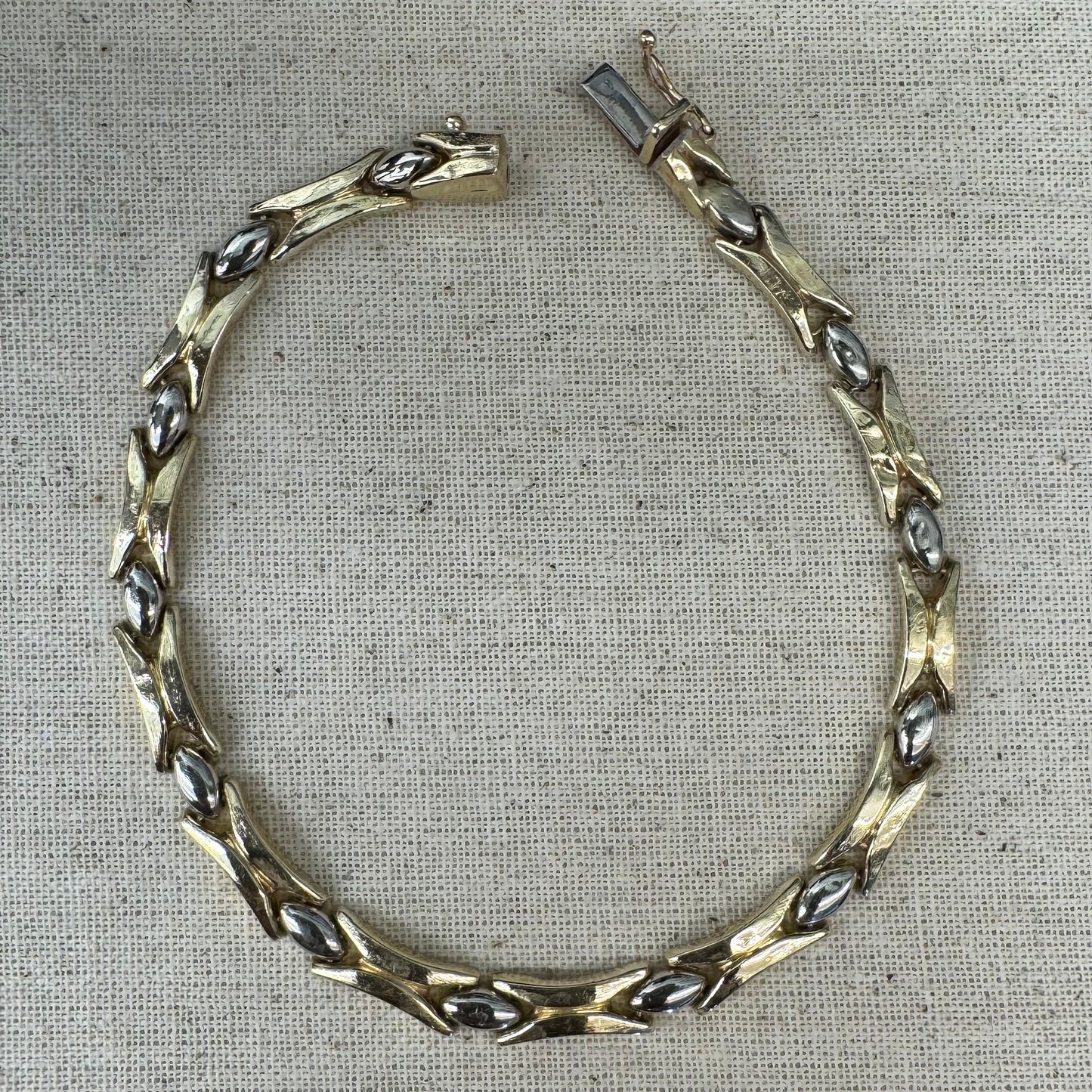 צמיד זהב צהוב וזהב לבן 14 קראט בעיצוב גאומטרי מיוחד, עם חיבורים בצורת X מזהב צהוב ושיבוצים מבריקים בזהב לבן