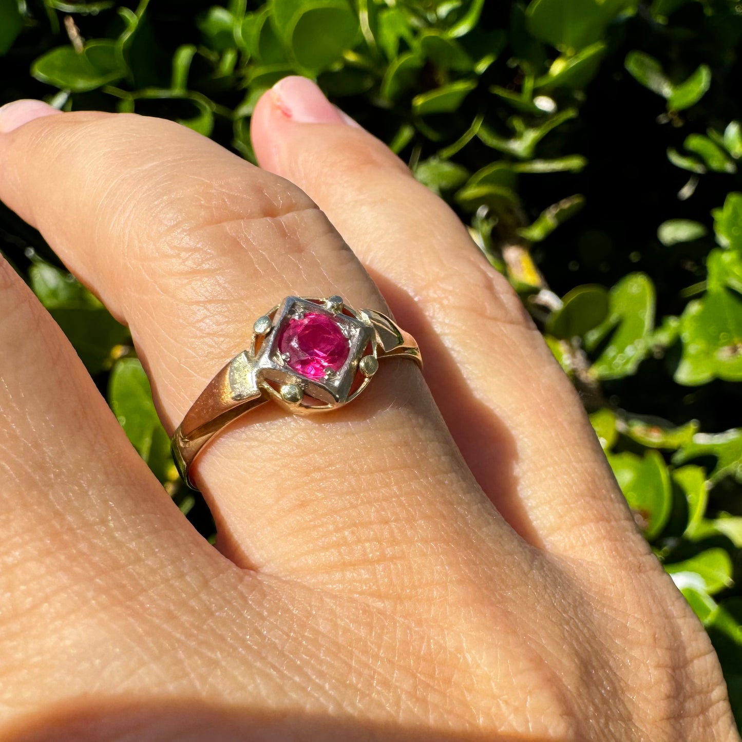 14K gold ring set with a vivid round-cut Ruby set in a geometric white gold frame.