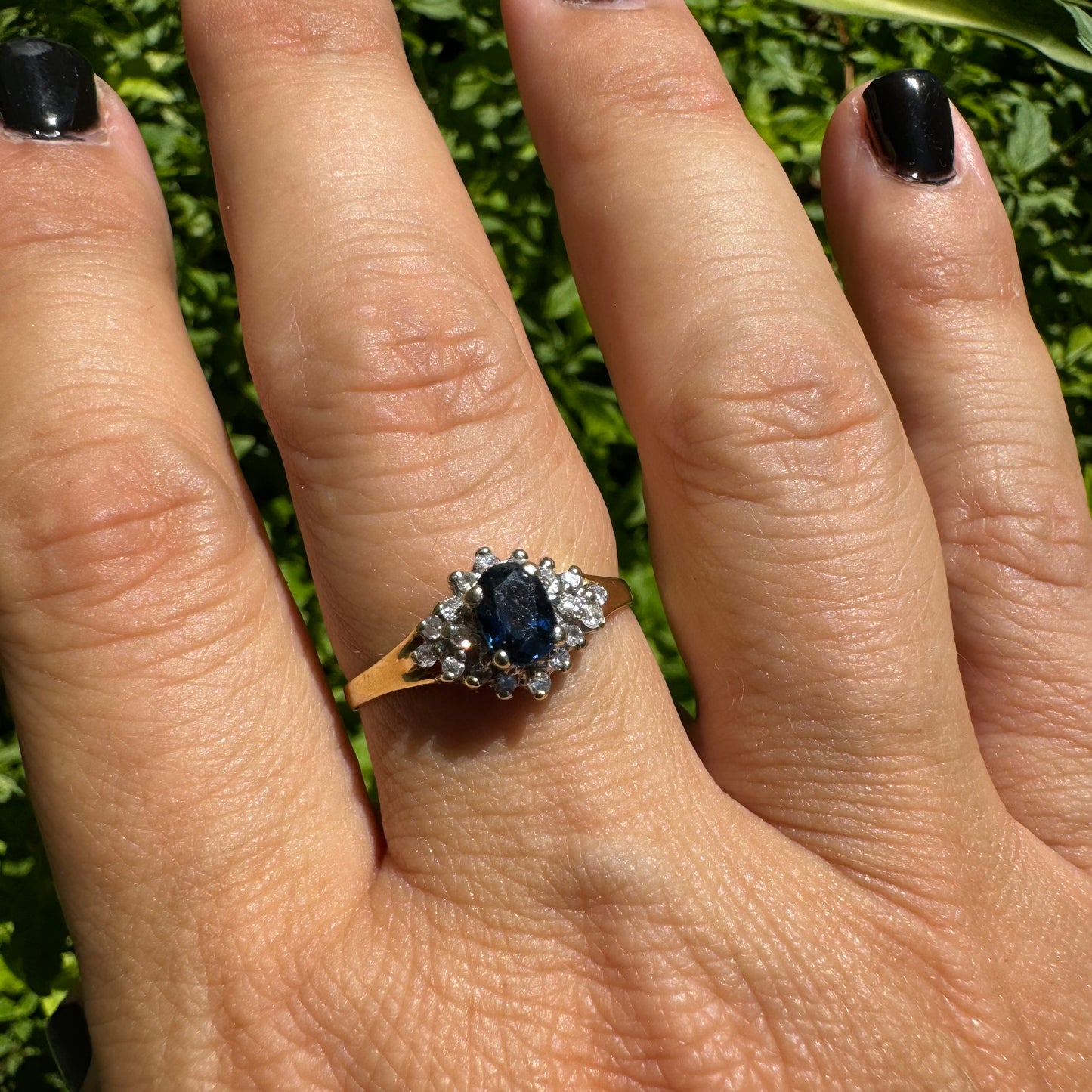 14K gold ring set with an oval blue Sapphire surrounded by sparkling Diamonds