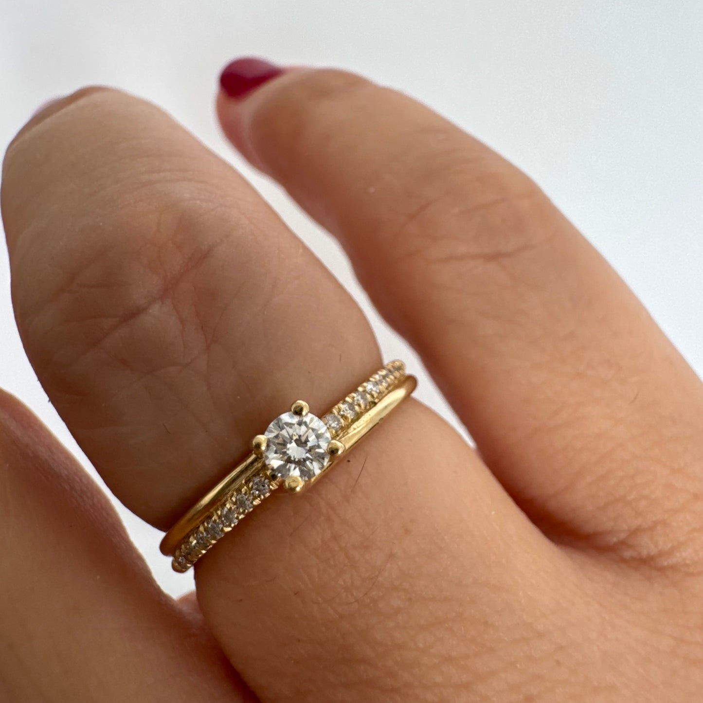 טבעת זהב צהוב 14 קראט משובצת יהלום מרכזי בחיתוך עגול ופס יהלומים עדין.