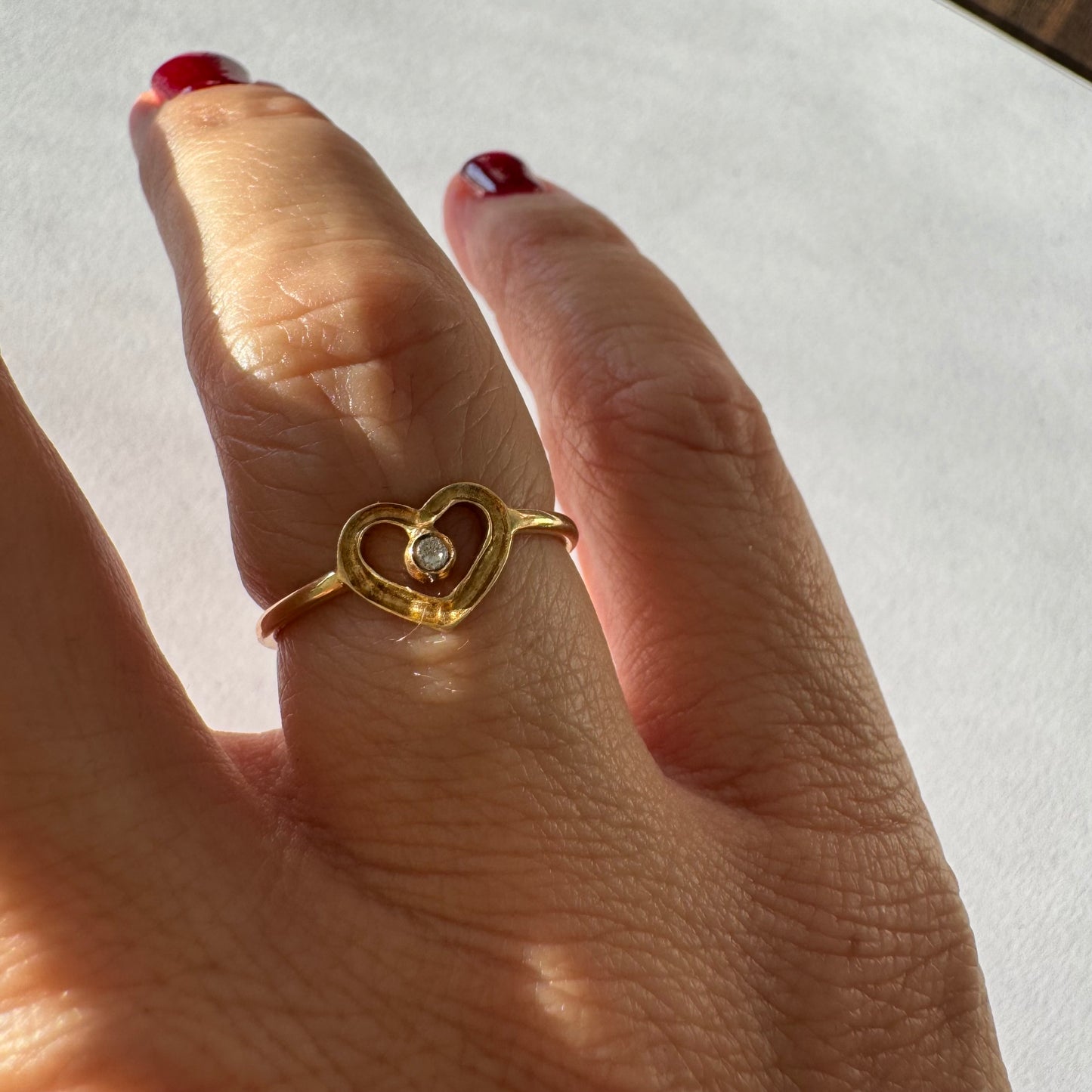 טבעת זהב 14 קראט בעיצוב לב פתוח ועדין, עם יהלום קטן במרכז שמוסיף נקודת אור אלגנטית. 