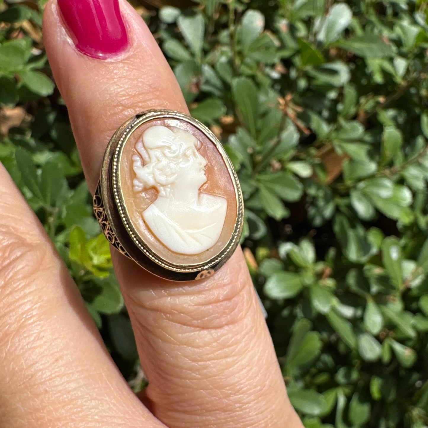 14K gold cameo ring featuring a finely carved portrait of a woman in profile, set in an oval bezel with intricate gold detailing
