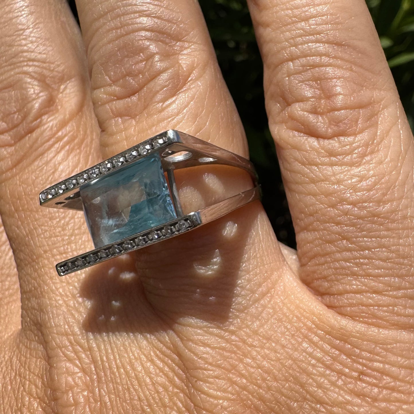 18K gold ring set with a stunning Aquamarine centerpiece held between two sleek gold bars set with delicate Diamonds.