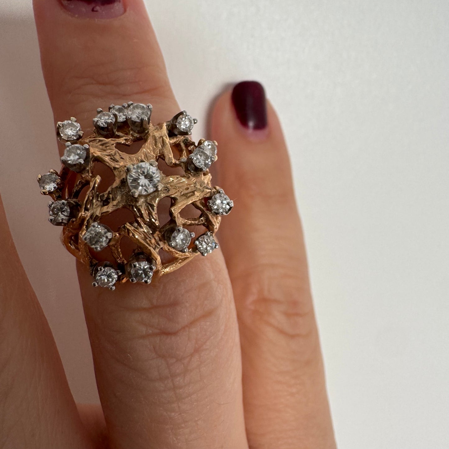 טבעת זהב 10 קראט בעיצוב פיסולי פתוח, משובצת יהלומים במבנה עגול דינמי.