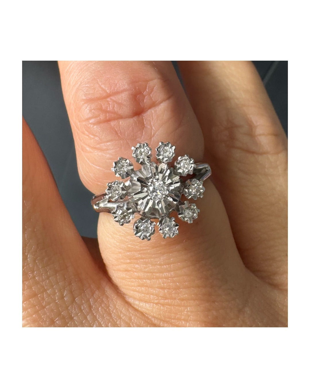 טבעת זהב 18 קראט משובצת יהלום מרכזי מוקף יהלומים נוספים בעיצוב פרח סימטרי ומרשים