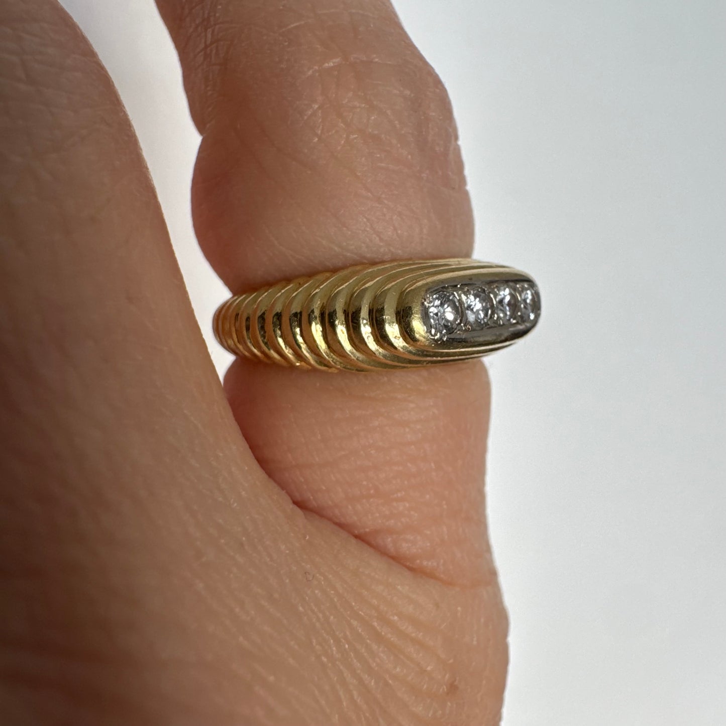 טבעת זהב צהוב 14 קראט בעיצוב אליפטי מוארך, משובצת חמישה יהלומים עגולים בשיבוץ תעלה.