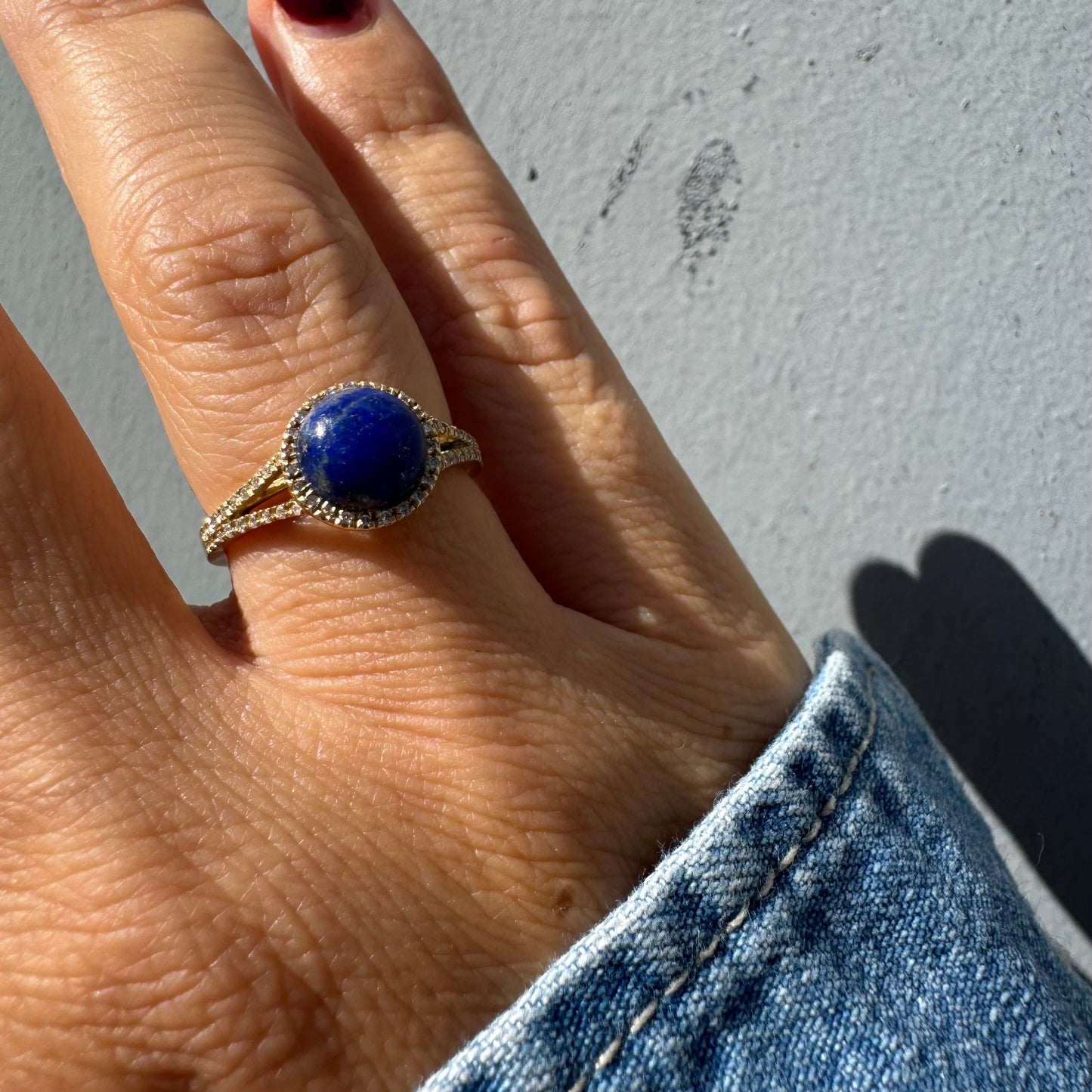 14K gold ring set with a round Lapis Lazuli gemstone, surrounded by a delicate halo of sparkling Diamonds.