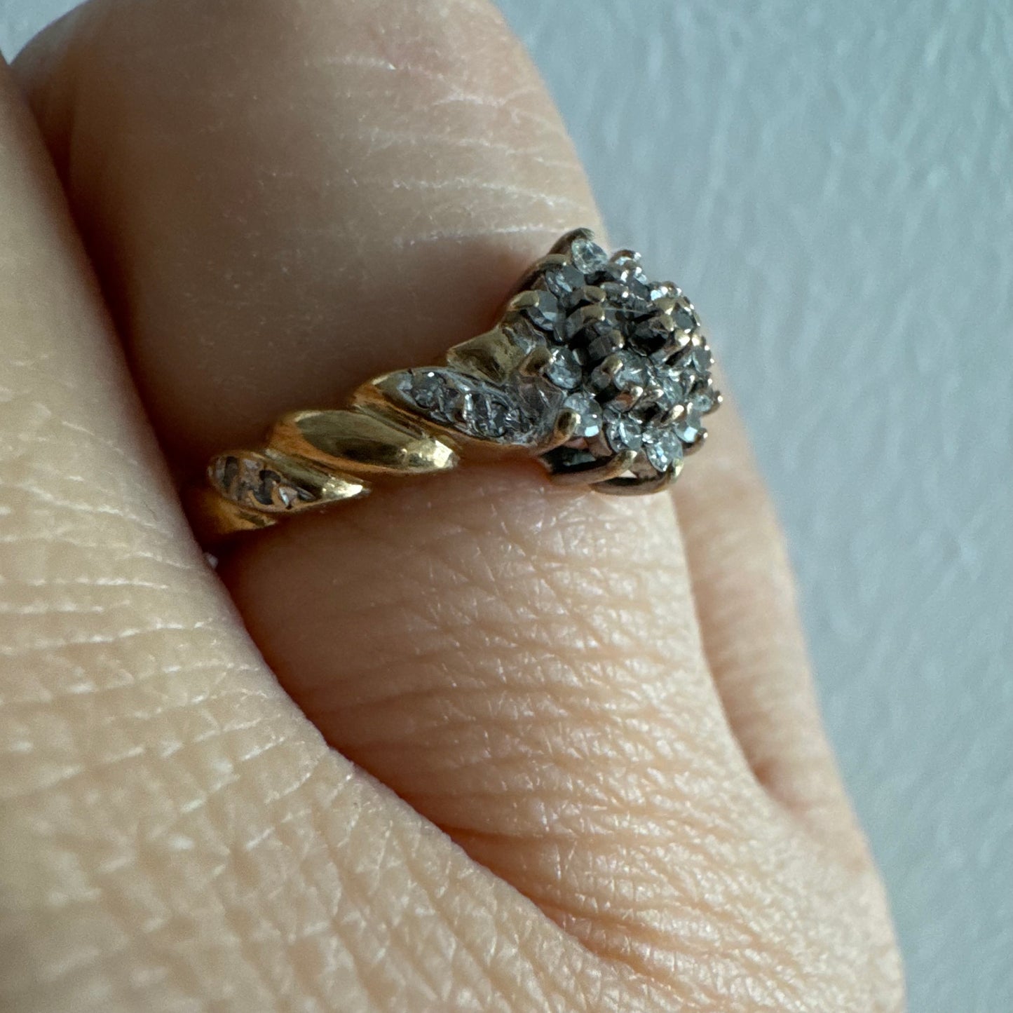 טבעת זהב צהוב 9 קראט משובצת יהלומים בעיצוב פרח עדין.