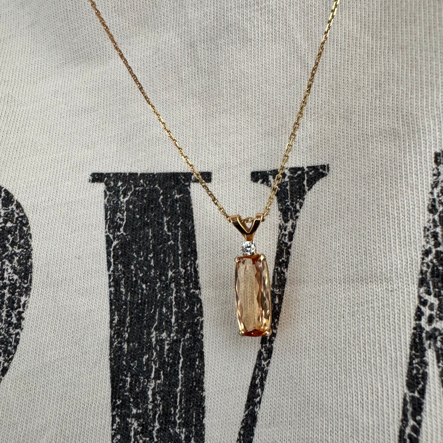 שרשרת זהב 14 קראט עם תליון זהב 14 קראט משובץ אבן קוורץ מלבנית בגוון שמפניה חמים, ומעליה יהלום נוצץ להדגשה עדינה של הברק.