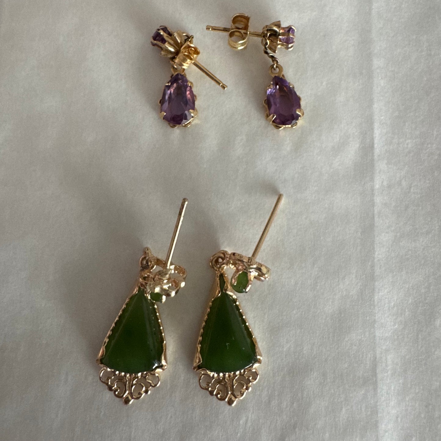 עגילי זהב צהוב 14 קראט משובצים אבני ג׳ייד ירוקות בגוון עמוק בחיתוך משולש.