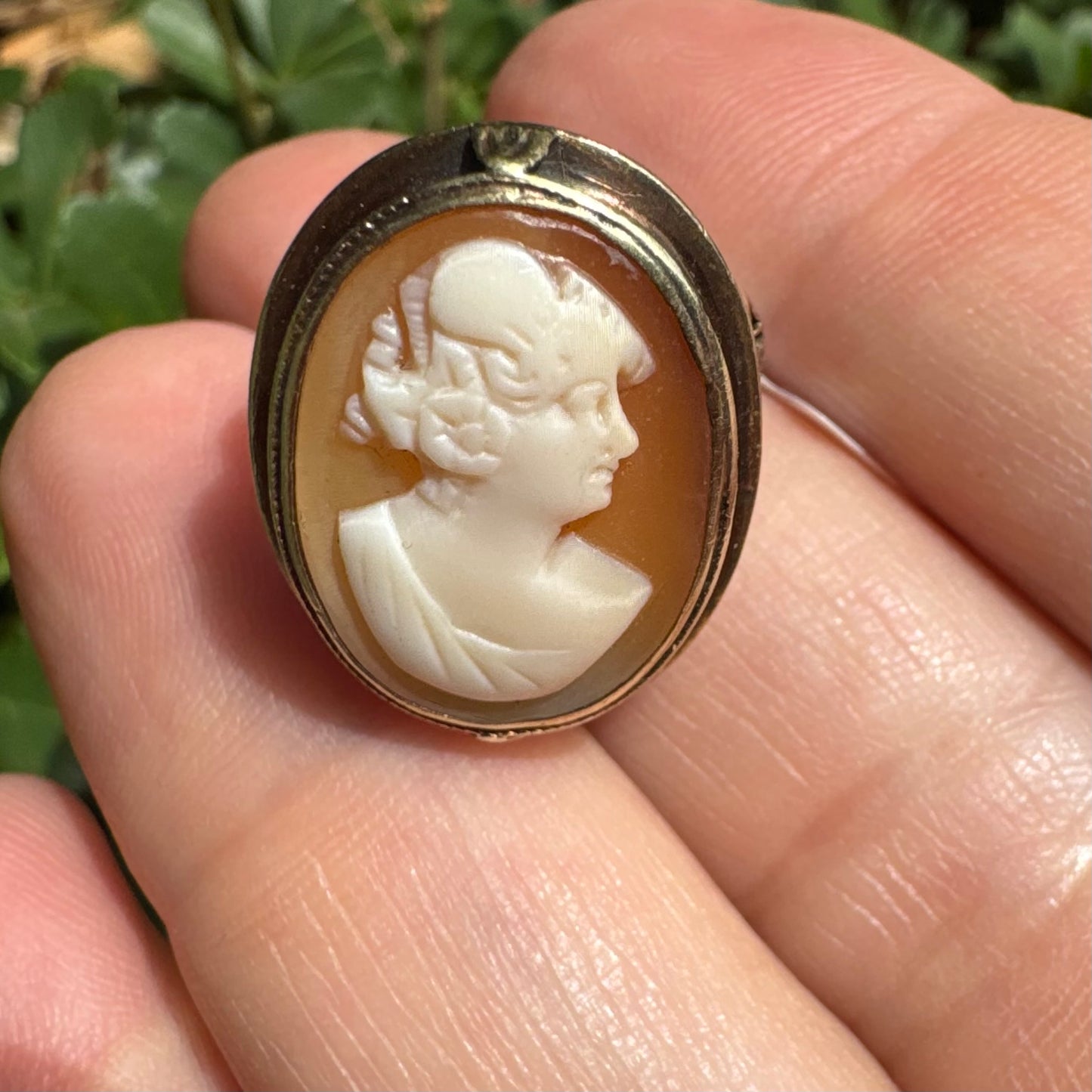 14K gold cameo ring featuring a finely carved portrait of a woman in profile, set in an oval bezel with intricate gold detailing