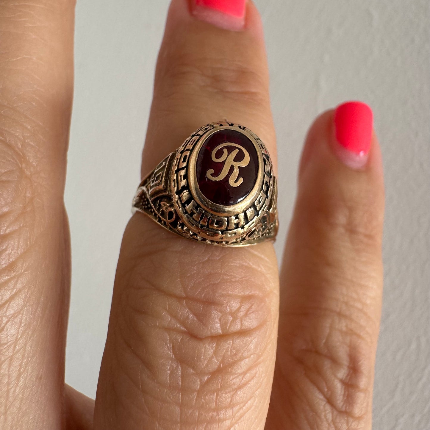 טבעת מחזור (Class Ring) מזהב 10 קראט, בעלת עיצוב אמריקאי קלאסי ובמרכזה אבן אדומה עם האות R עם חריטות וסמלים המעניקים לה אופי ייחודי ונוסטלגי.