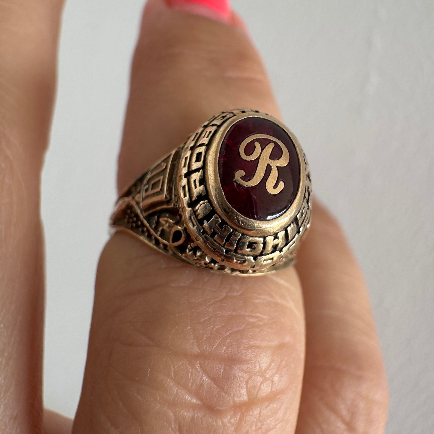 טבעת מחזור (Class Ring) מזהב 10 קראט, בעלת עיצוב אמריקאי קלאסי ובמרכזה אבן אדומה עם האות R עם חריטות וסמלים המעניקים לה אופי ייחודי ונוסטלגי.