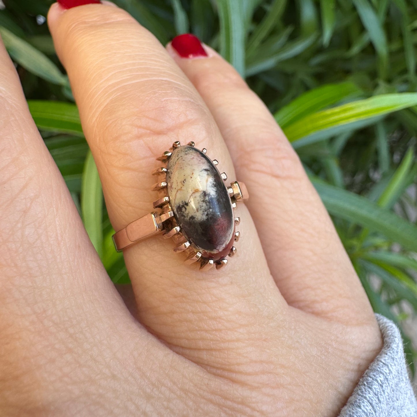 טבעת זהב 14 קראט משובצת אבן ג’ספר ייחודית בגווני קרם, שחור ואדום. 