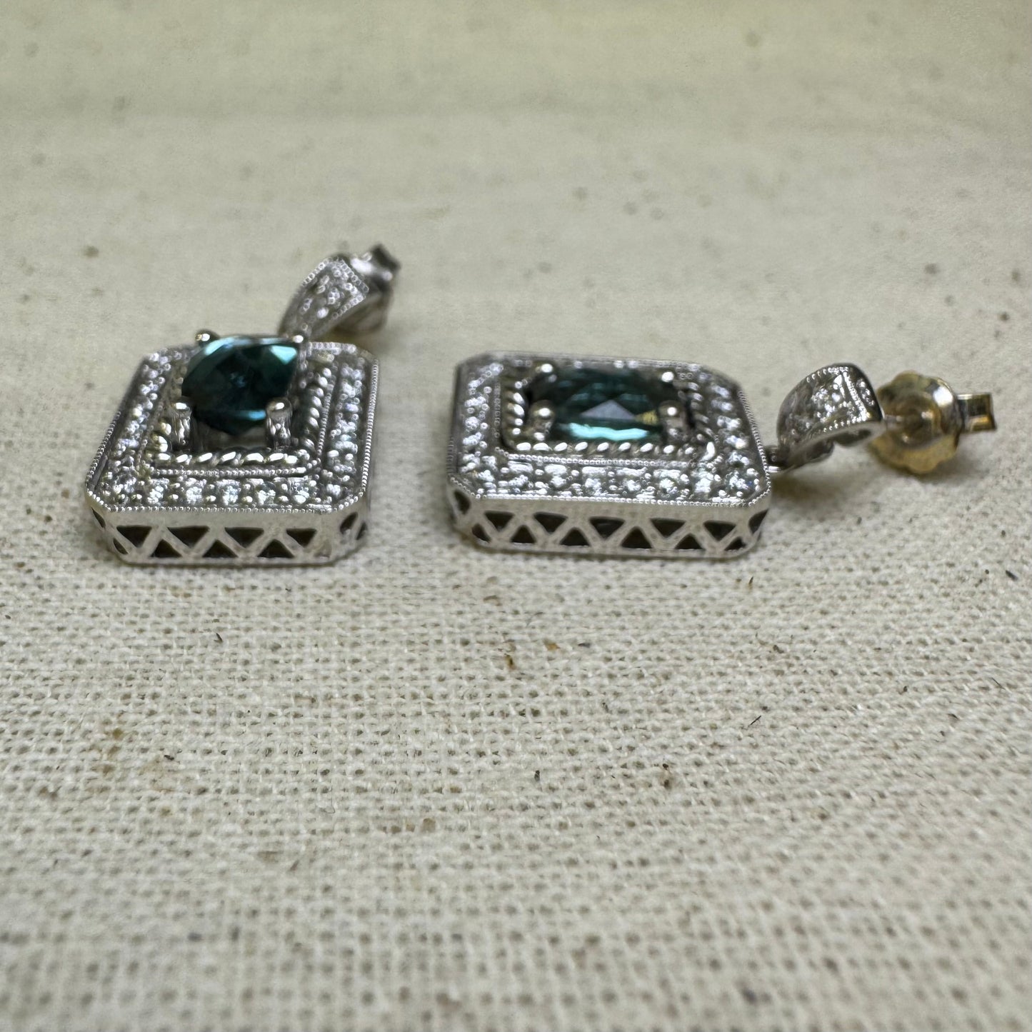 14K gold drop earrings set with emerald-cut Blue Topaz, surrounded by a halo of sparkling Diamonds