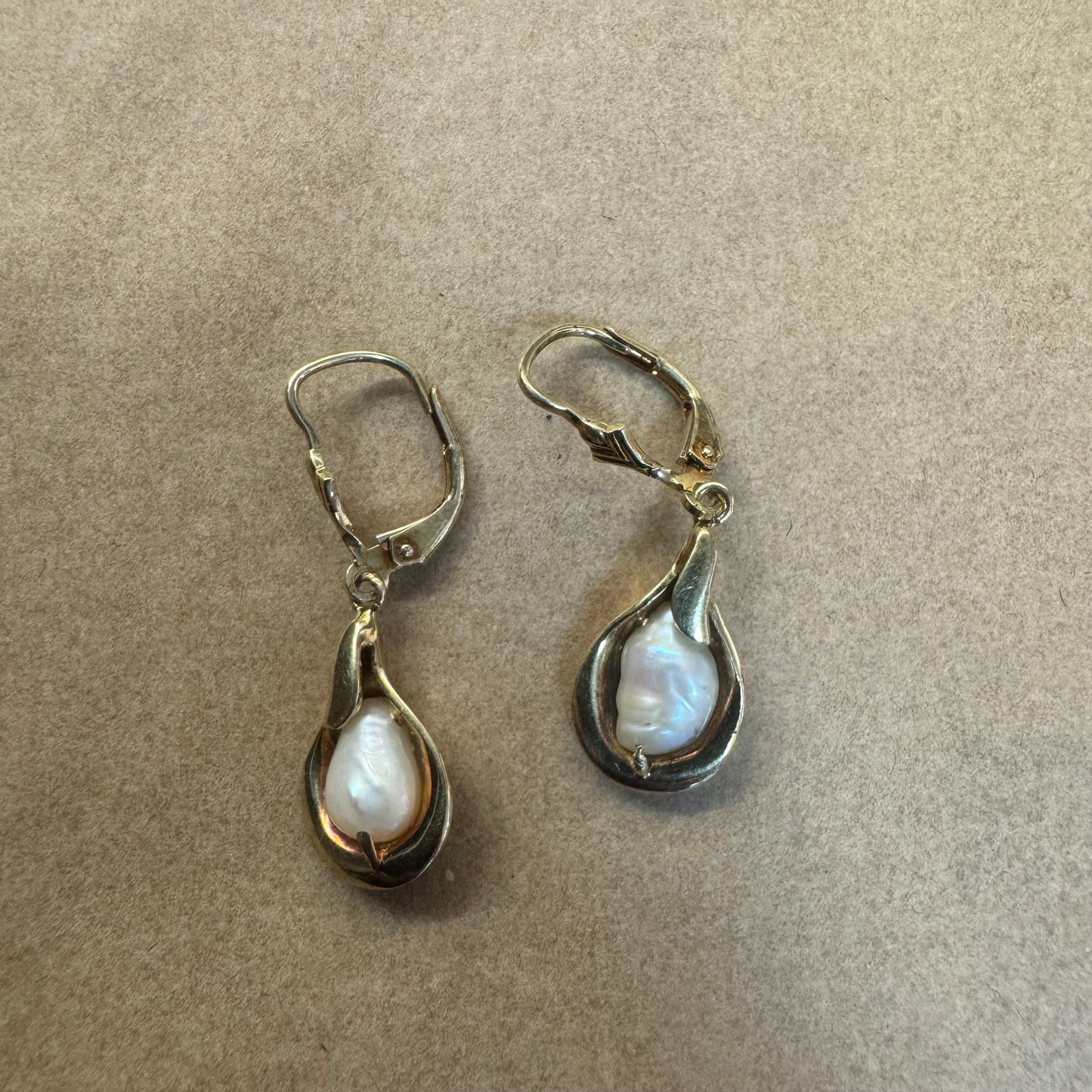 עגילי זהב צהוב 14 קראט משובצים פניני בארוק בעיצוב נוזלי ורך שמדגיש את היופי הטבעי של הפנינה