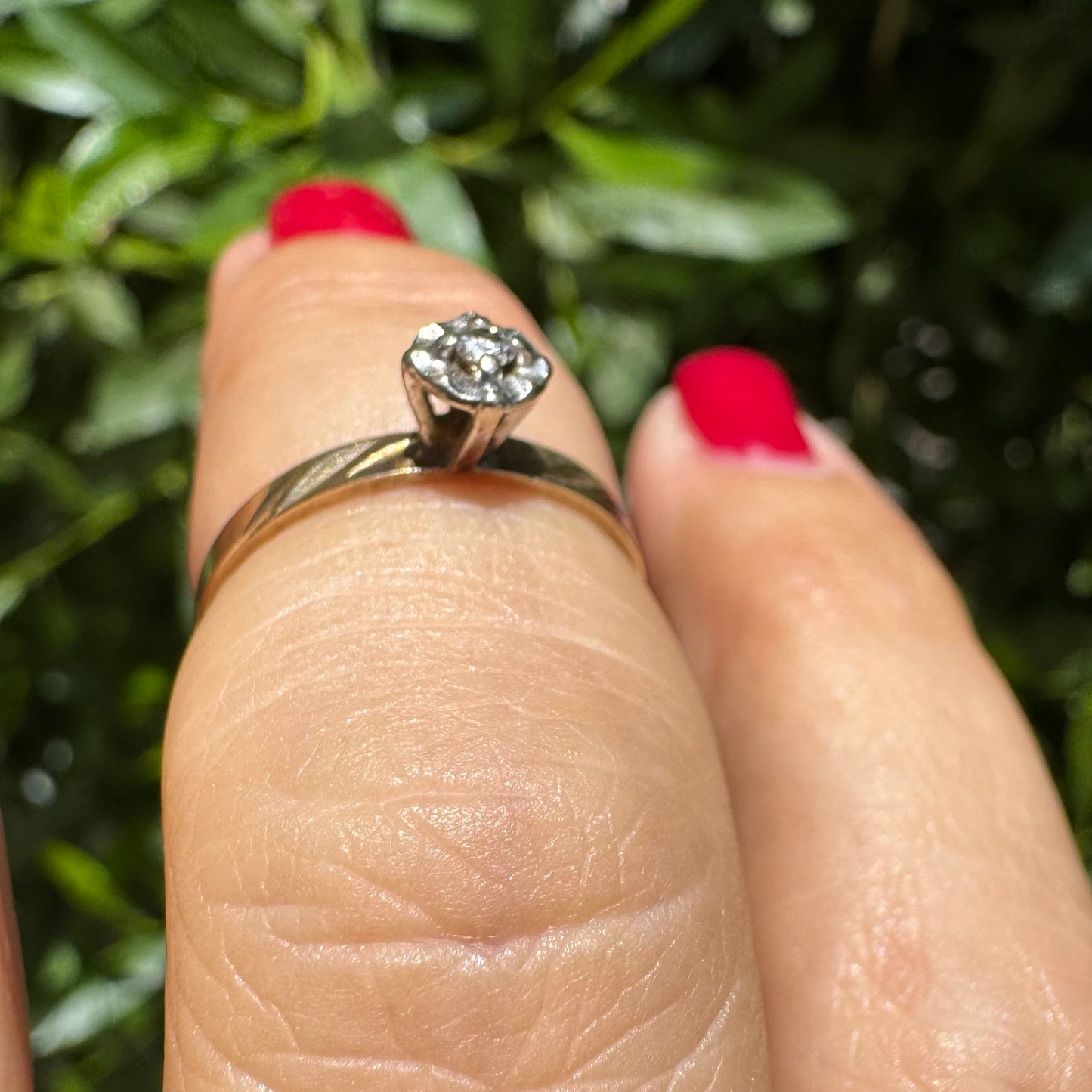 14K gold ring with a delicate floral-style setting, set with a small central Diamond.