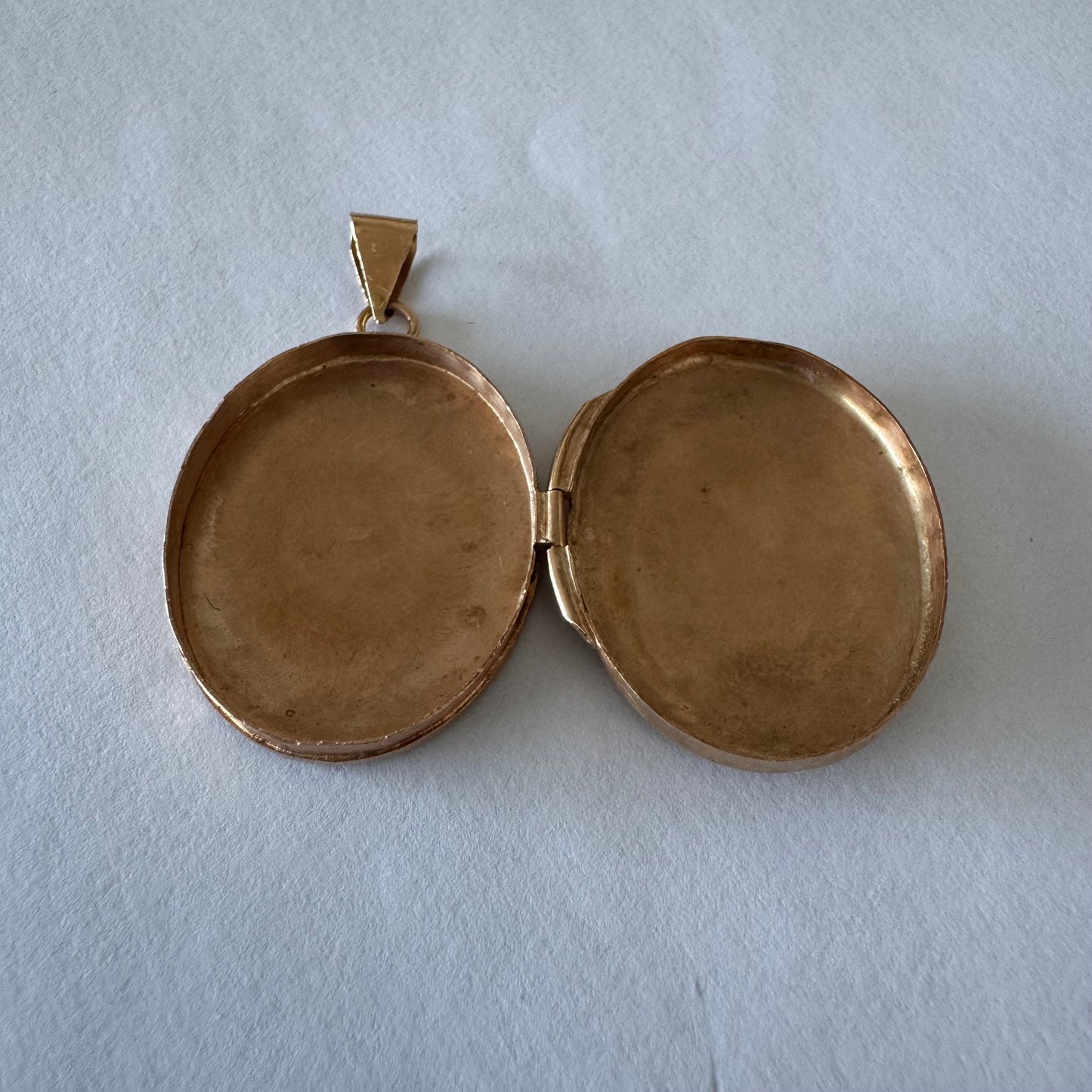 תליון לוקט זהב 14 קראט אובלי עם עיטור חריטה פרחית עדינה בעבודת יד ומסגרת אלגנטית ופתיחה לשמירת זיכרון קטן ויקר ללב.